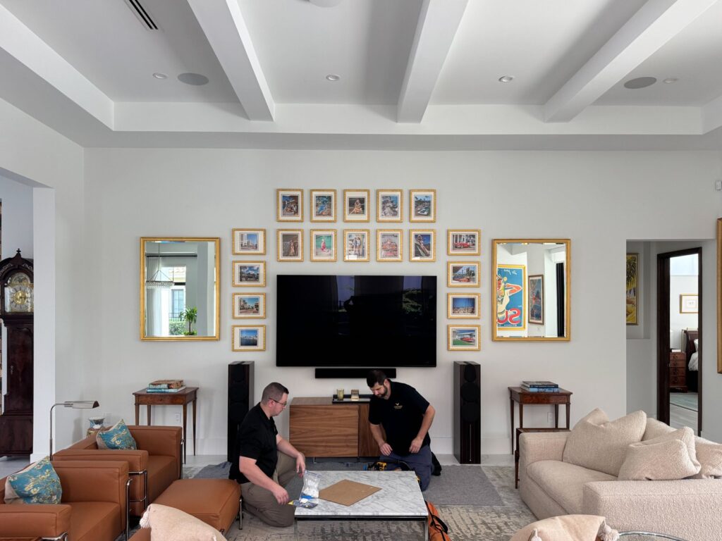 Firehawk installers Robert and John with a finished gallery wall and two mirrors around a TV